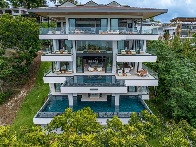 The villa set into dense rainforest, pools visible on two levels