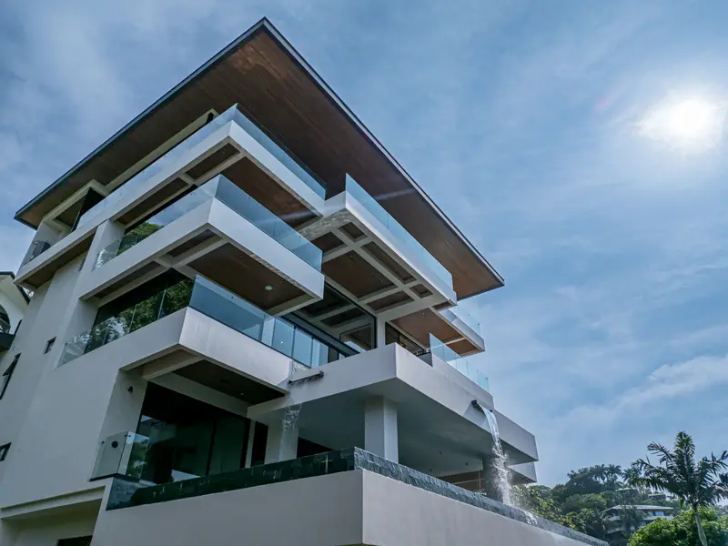 Stacked balconies and deep overhangs against a bright sky