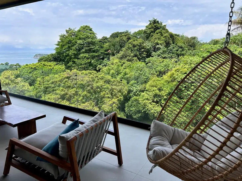 Hanging rattan chair on a terrace above the jungle