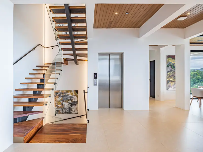 Floating timber staircase beside the elevator connecting all five levels