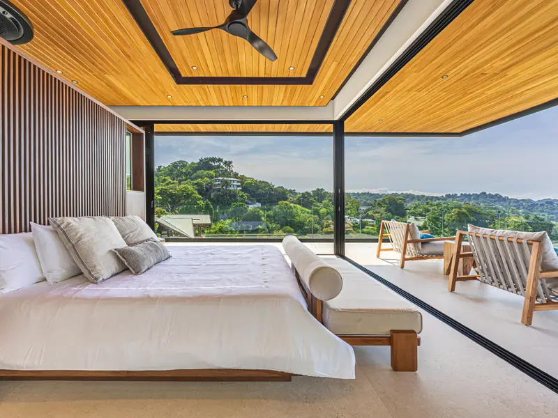 King suite with a slatted timber headboard wall and jungle outlook