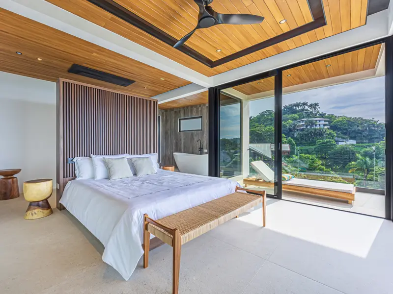 Crisp white linens and timber ceiling in an ocean-facing suite