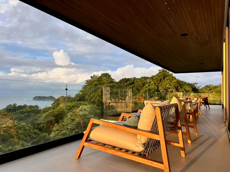 Loungers on the terrace as the light drops over the bay