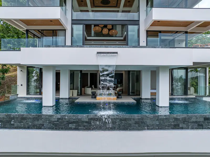 The villa's front elevation with the water feature and pool